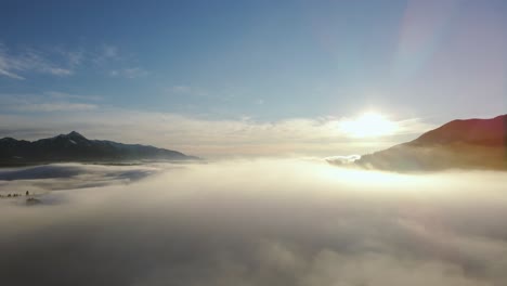 Toma-De-Un-Dron-De-Un-Increíble-Paisaje-Cubierto-Bajo-La-Niebla-Con-Montañas-Circundantes-En-La-Mañana-En-Invierno-En-Eslovenia-Capturado-En-4k,-Dron-Avanzando-En-La-Niebla