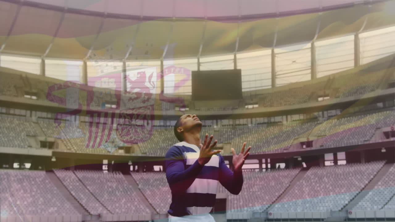Catching rugby ball, player in striped jersey in animation-filled stadium