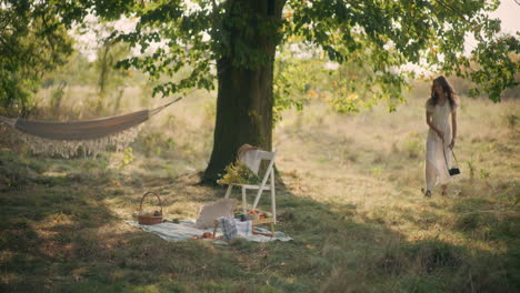 smiling girl walking with film camera in the meadow