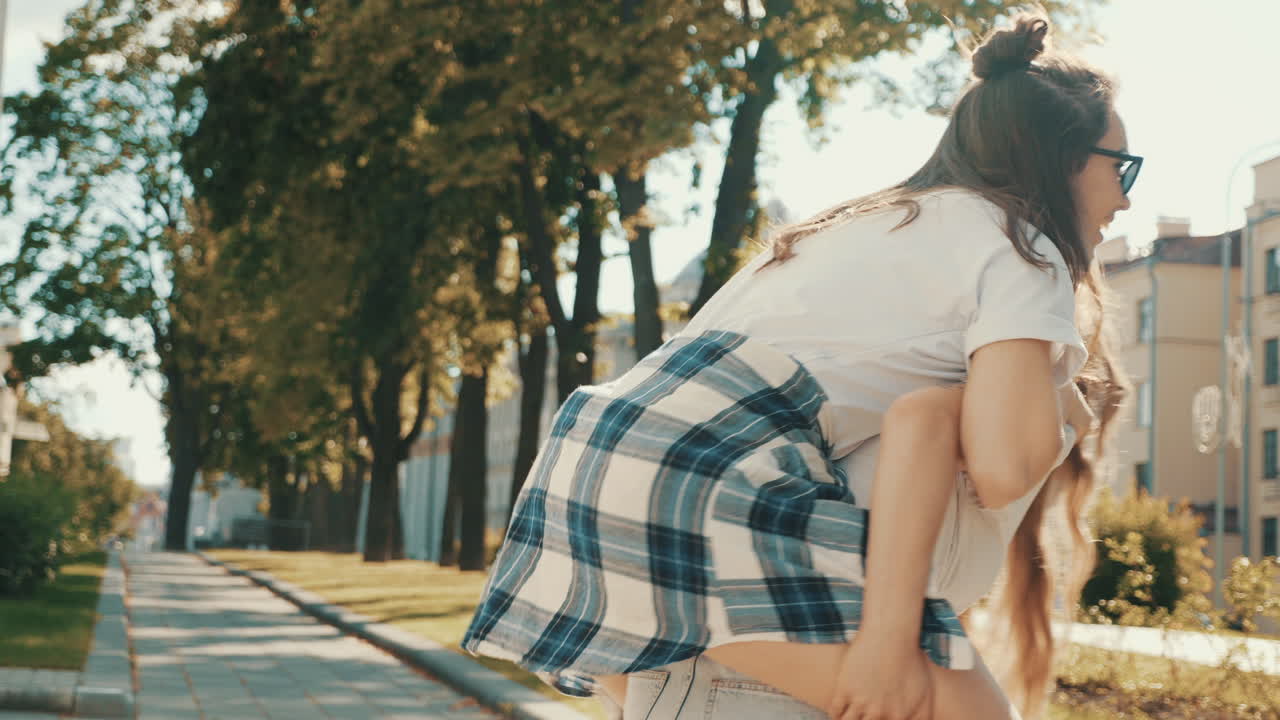 두 명 의 행복 한 친구 들 이 도시 공원 에서 즐겁게 지내고 있다