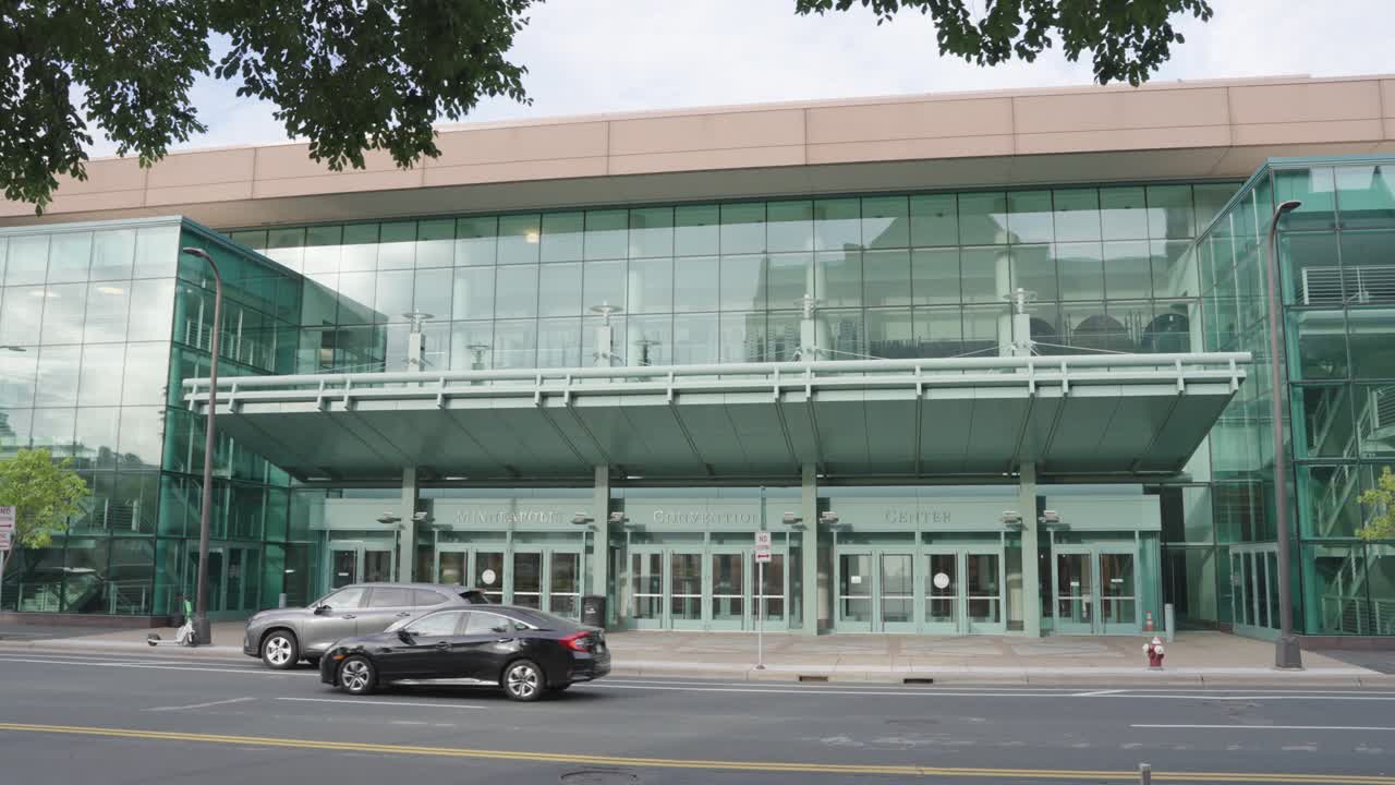 미네아폴리스 컨벤션 센터의 유리 밖을 지나가는 차량.