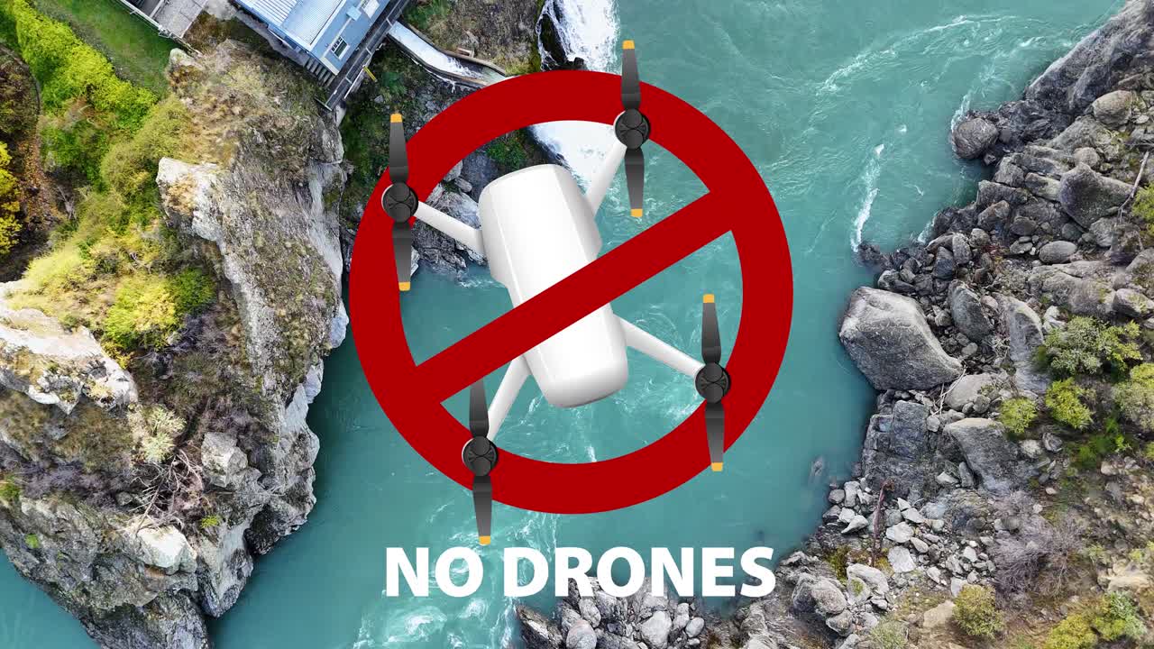 Aerial view of a drone flying over a turquoise river in a rocky canyon, followed by a no-drone warning symbol