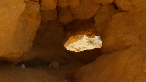 caves and holes at the red cliffs of praia do evaristo beach in algarve, portugal