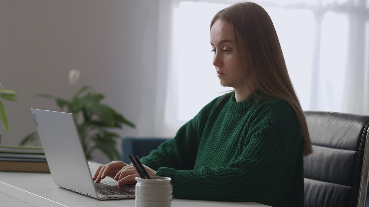 young female boss is working in her office room sending messages and emails by laptop online chat and communicating in social nets at work time medium portrait