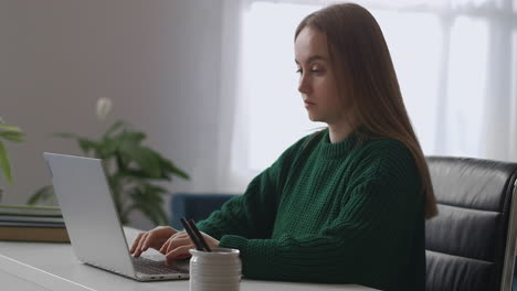 young female boss is working in her office room sending messages and emails by laptop online chat and communicating in social nets at work time medium portrait