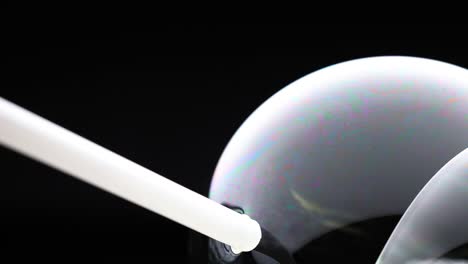 vibrant soap bubble reflects colors in dark environment, showcasing fluid motion and iridescence over 33 seconds