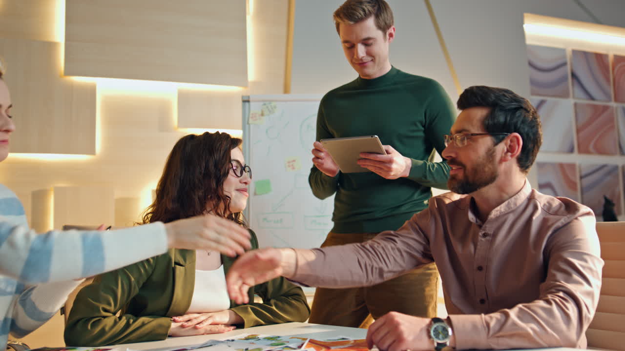 equipo feliz apretando la mano en la sala de juntas. compañeros de trabajo regocijándose de una colaboración exitosa