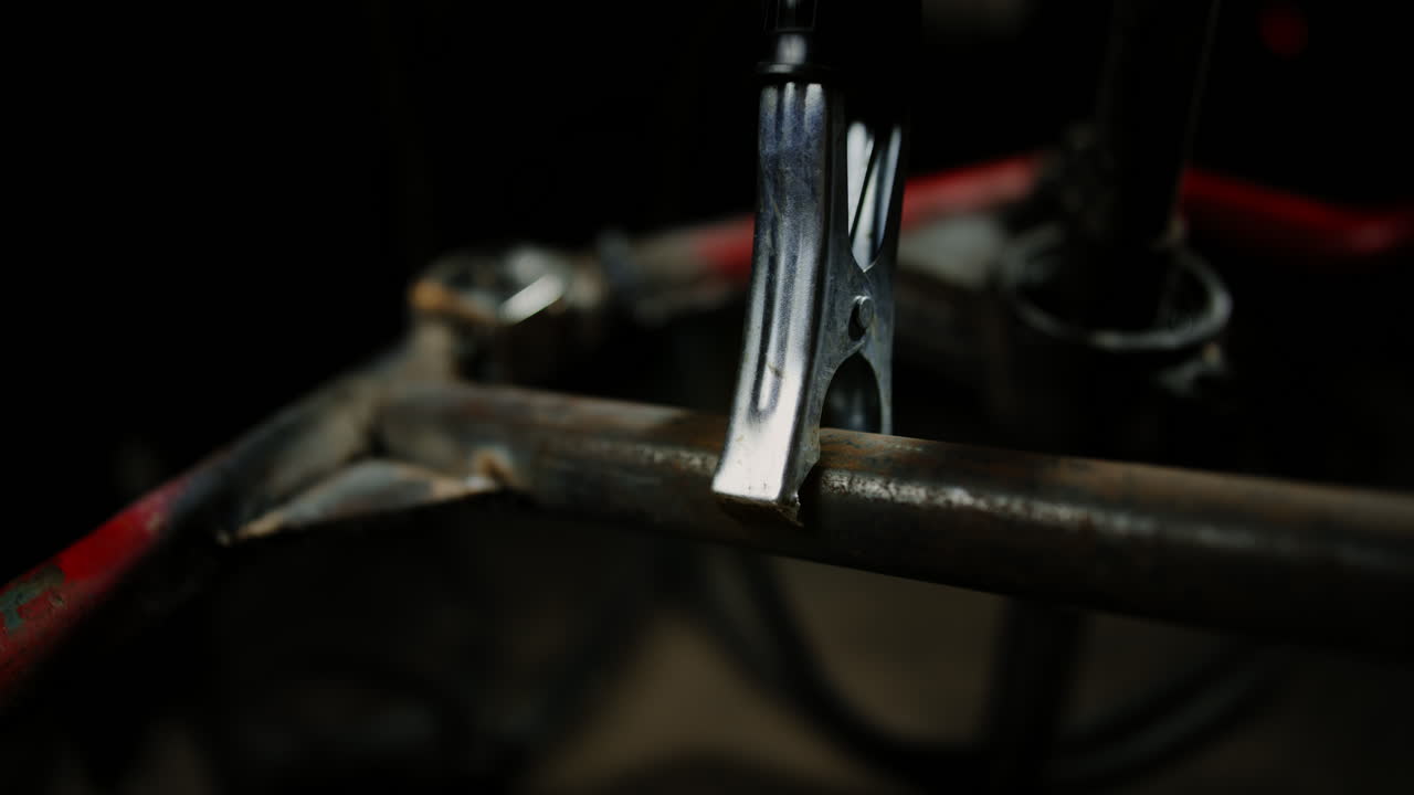 en el taller, el mecánico está ocupado reparando el coche, sujetando el ánodo de una máquina de soldadura, usando su experiencia y herramientas para abordar cualquier problema y restaurar su funcionalidad