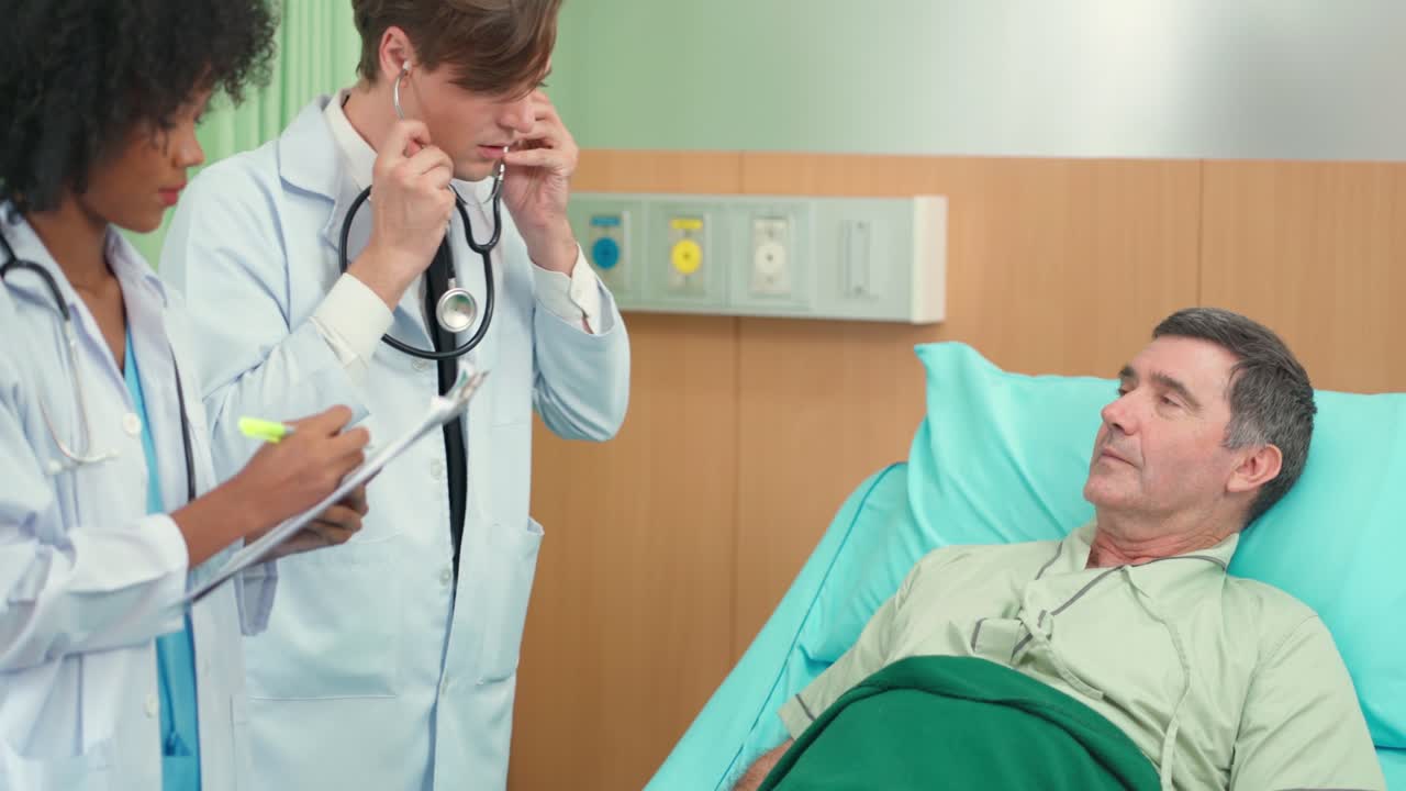 Doctor and assistance nurse visit patient in the room and using stethoscope checking up heart beat rate. Older man lying on the bed and breathe in and breathe out during doctor listening.