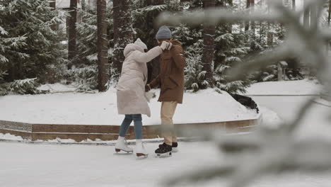 pareja patinando en el parque de invierno