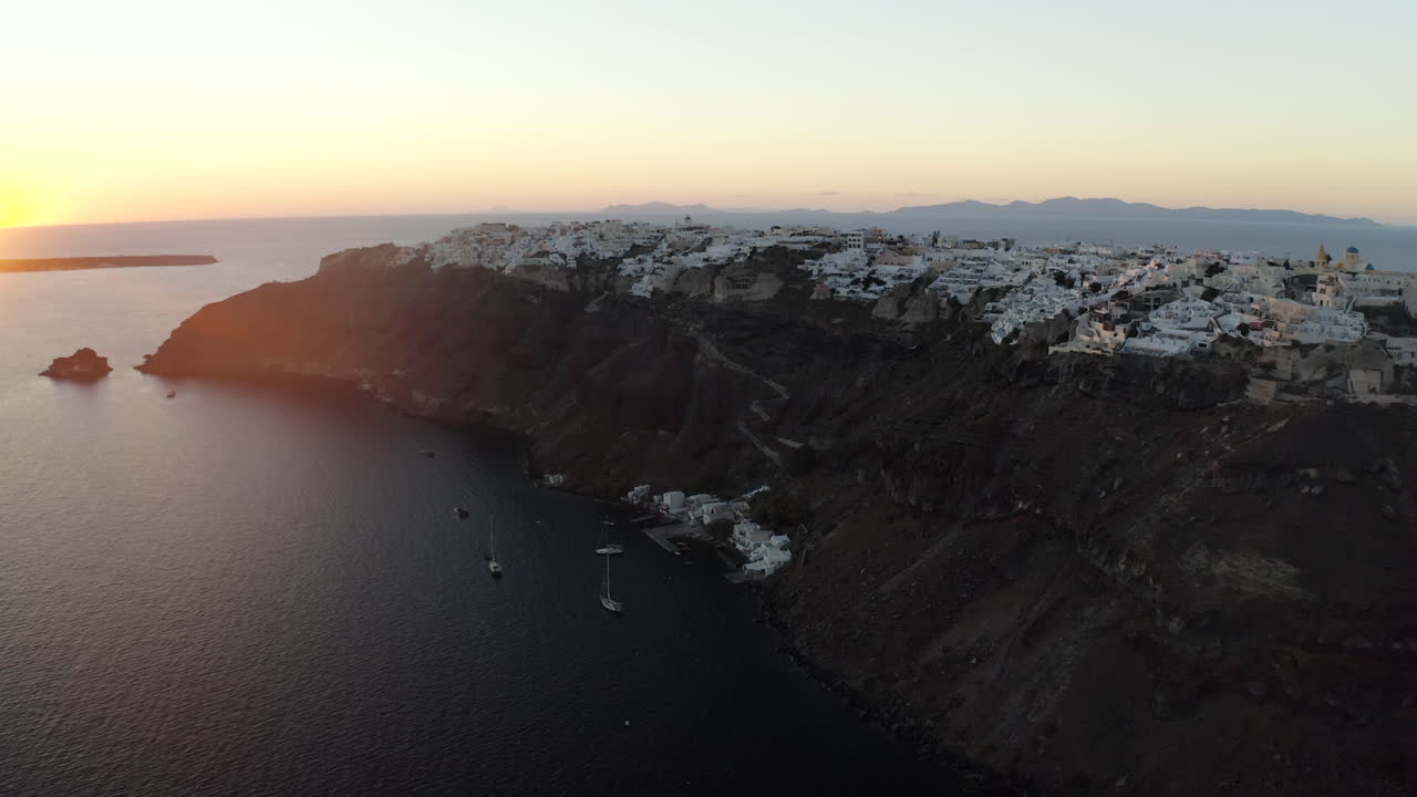 oia santorini island sunset drone shot con vistas a edificios blancos y al mar, grecia en 4k