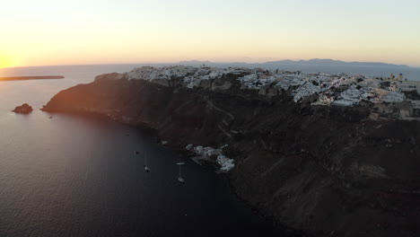 oia santorini island sunset drone shot overlooking white buildings and the sea, greece in 4k