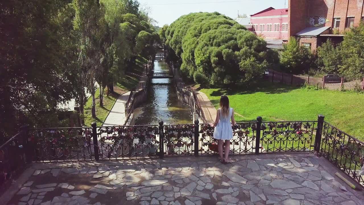 vista del canal con cerraduras de amor y mujer en vestido blanco