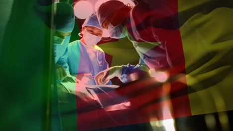 animation of flag of cameroon waving over surgeons in operating theatre