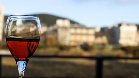 red wine glass with reflective cityscape background