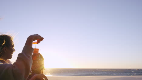 Girl-friends-blowing-bubbles-on-beach-at-sunset-slow-motion