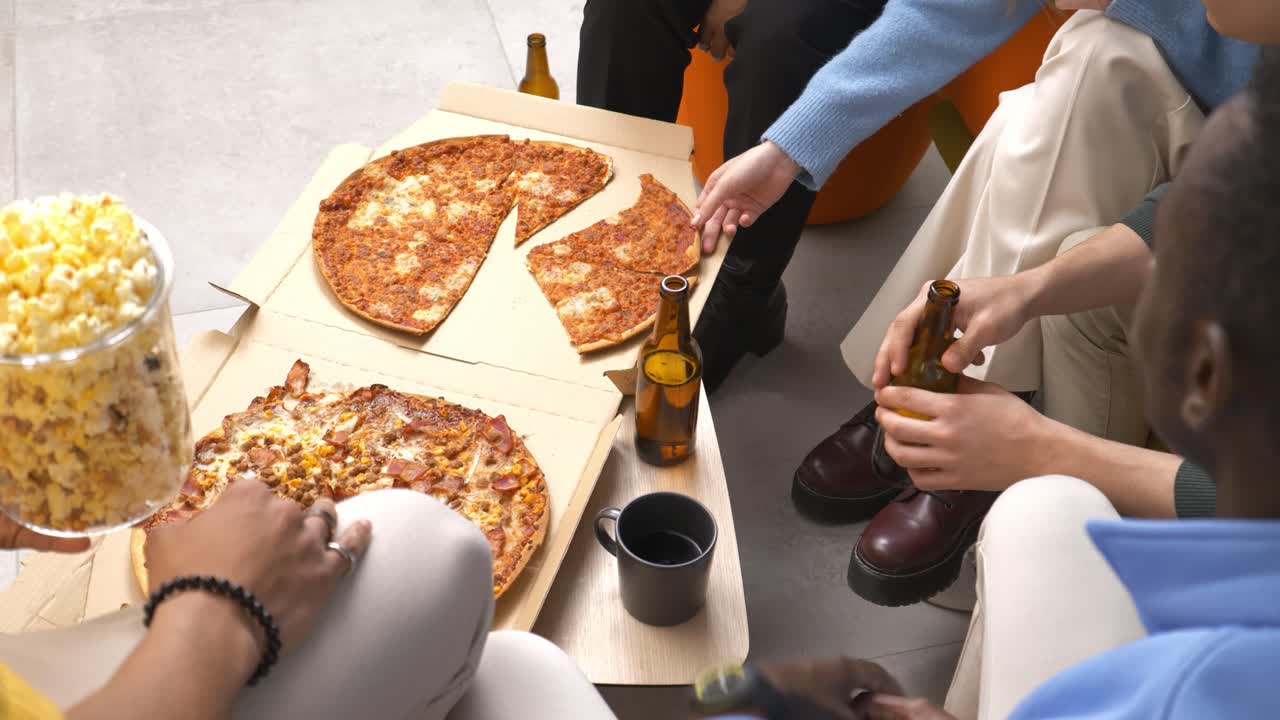 Friends sharing pizza and beer during break time