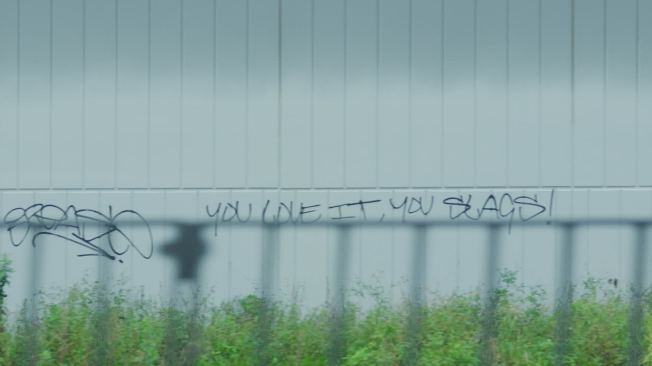 filmando desde una ventana de tren durante el amanecer pasando graffiti en la pared de un edificio en sídney australia