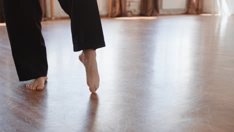 bare feet practicing dance steps on a wooden studio floor