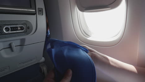 fotografía de una mujer abriendo zapatillas desechables en un avión