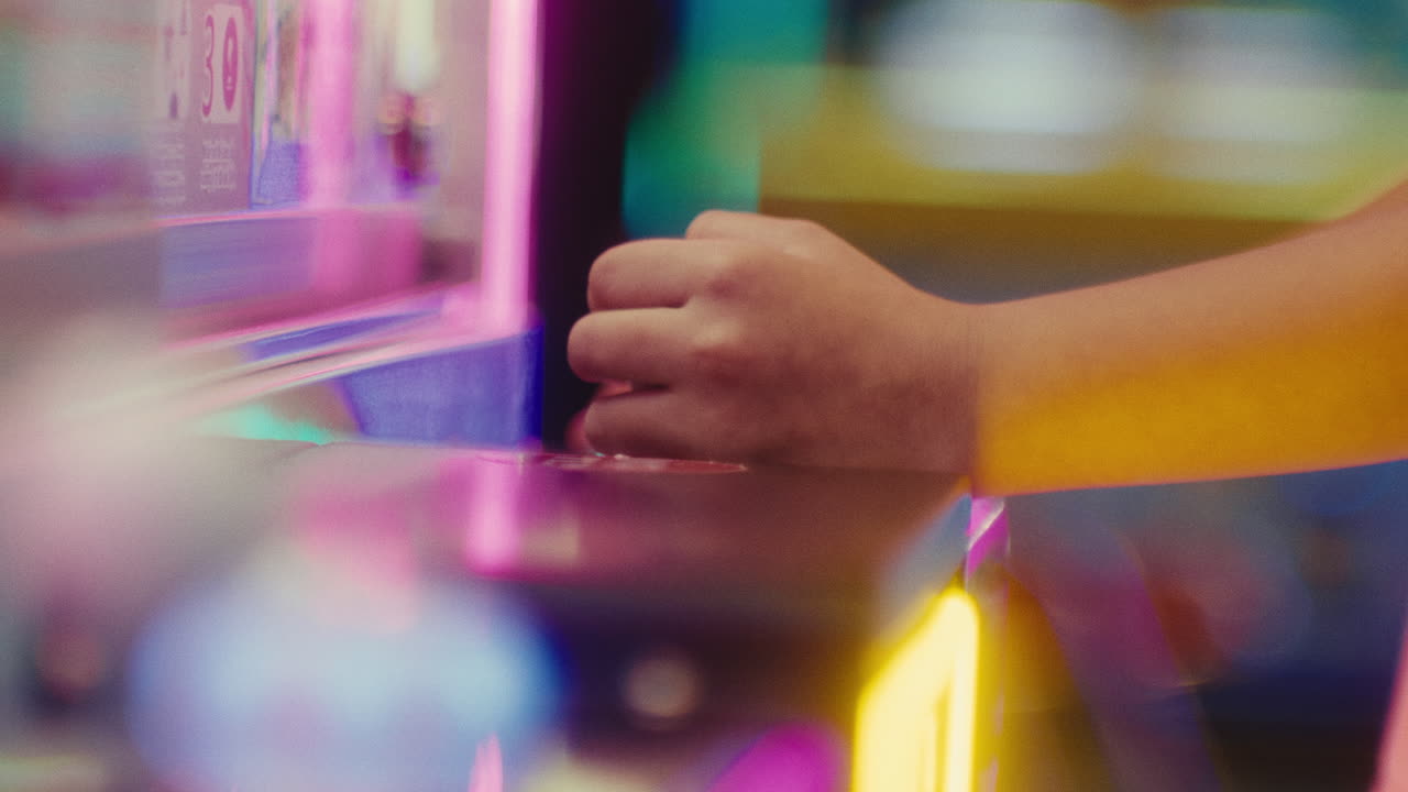 niño con manos hábiles controlando el botón del controlador de joystick rápido en la sala de videojuegos arcade, cerca de las manos de los jugadores