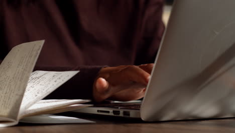 mujer escribiendo en una computadora portátil, trabajando desde casa