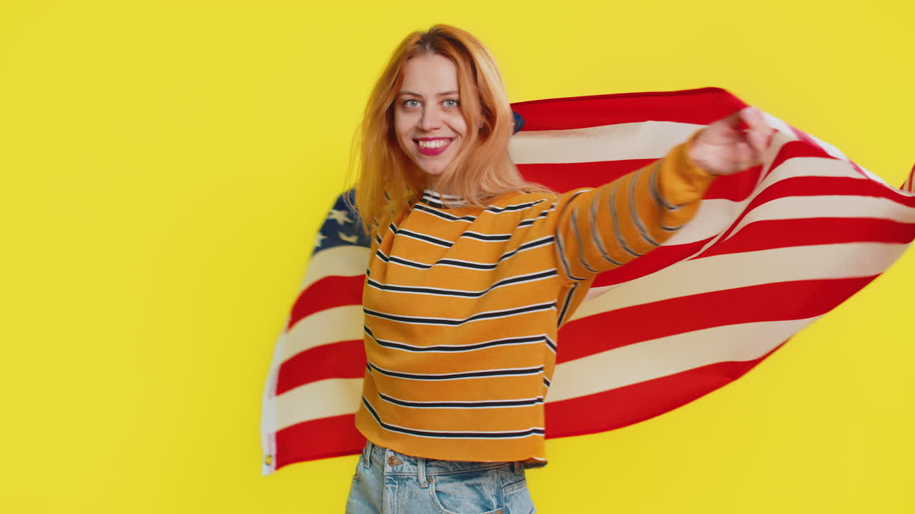 Blonde young woman waving and wrapping in american usa flag celebrating human rights and freedoms