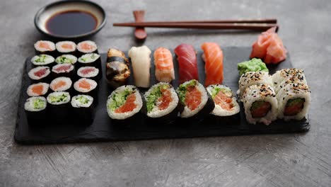 composition of different kinds of sushi rolls placed on black stone board