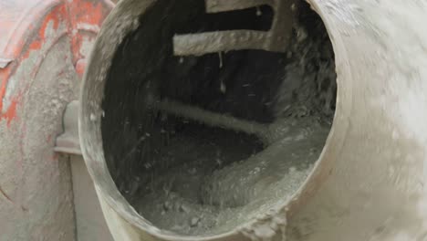 trabajador de la construcción masculino haciendo mezcla de hormigón usando mezcladora de cemento girando en cámara lenta