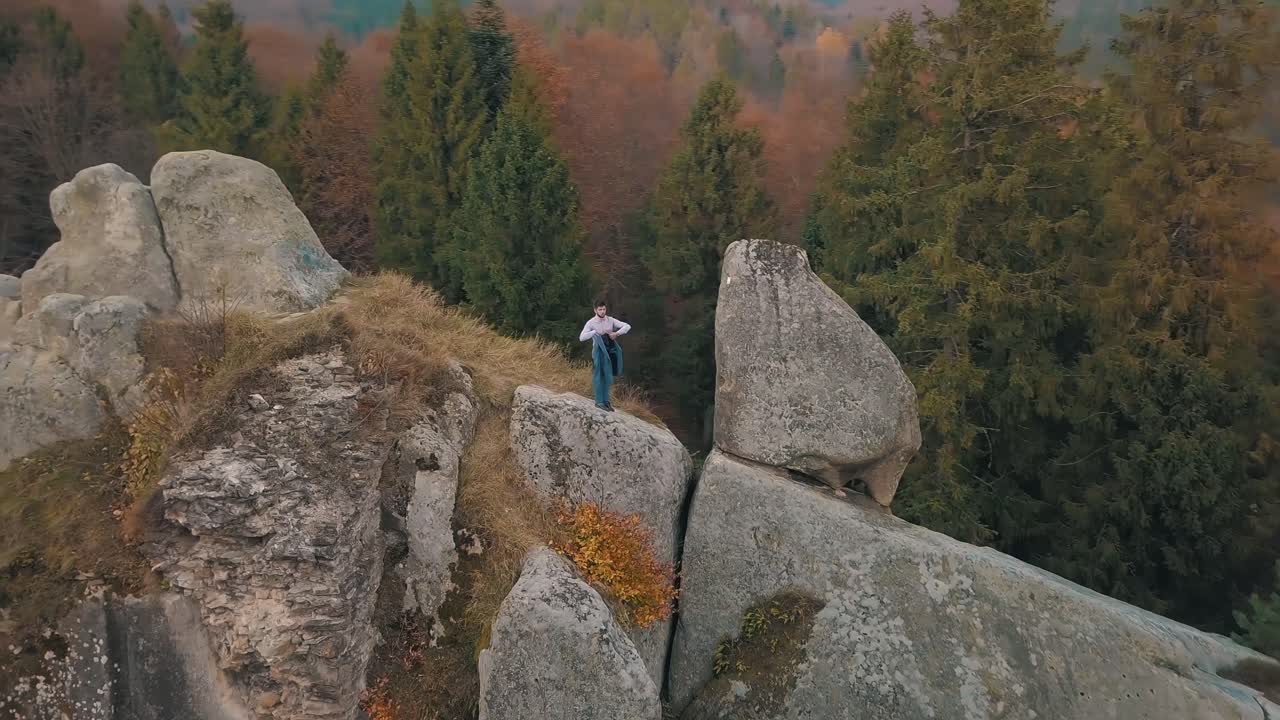 Молодой человек на склоне горы. Бизнесмен. Жених. Вид сверху.