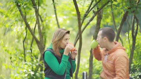 couple in nature drinking tea. happy couple drinking black tea together outdoors in nature