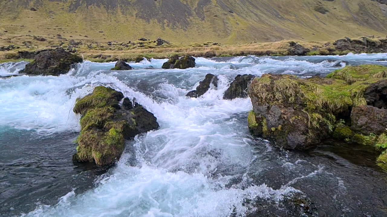 Slowmotion af gletsjerflodens strømfald i Islands landskab