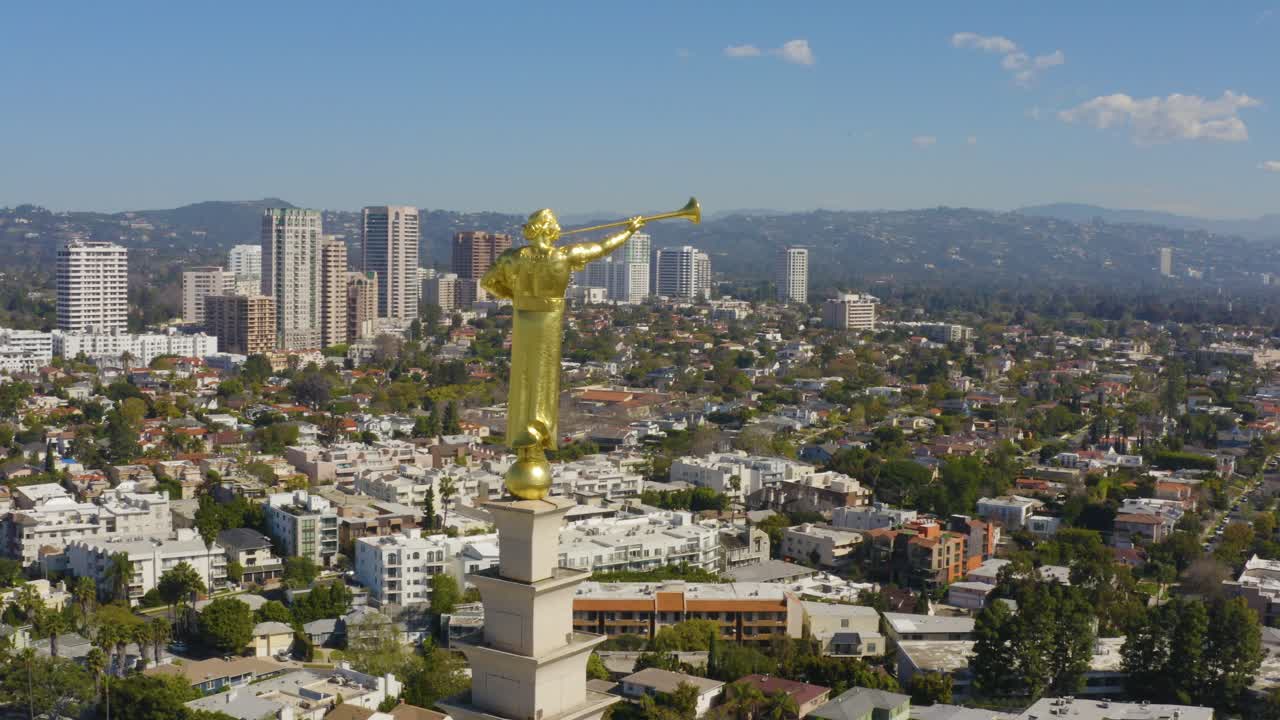 시내 건물과 함께 아름다운 황금색 건물 동상을 둘러싼 영화적인 공중 비행