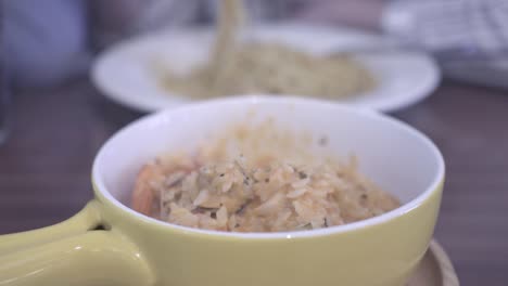 a child eats seafood risotto in a restaurant.