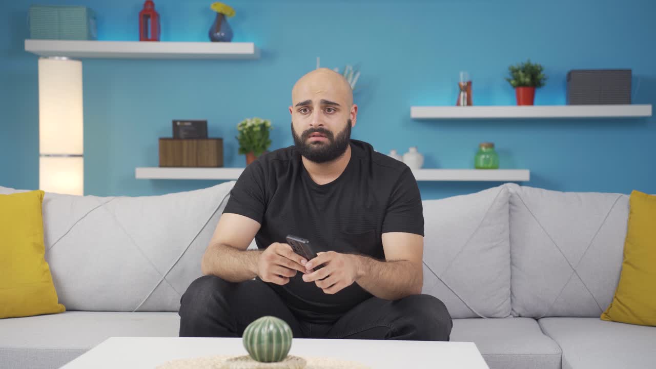Uomo deluso mentre messaggia.