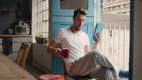 morning coffee for trendy man happy at home in pajamas using digital tablet