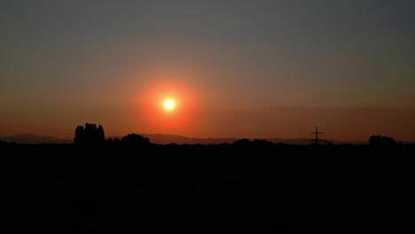 Luftaufnahme-Eines-Wunderschönen-Orangefarbenen-Sonnenuntergangs-Und-Einer-Natursilhouette---Drohnenaufnahme
