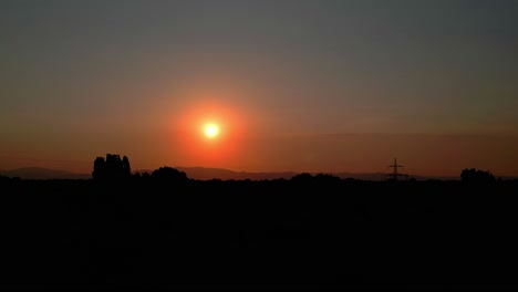 aerial view of a beautiful orange sunset and nature silhouette - drone shot