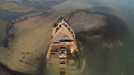 Shipwreck-In-Breidamerkursandur,-South-Iceland---Abandoned-And-Rusted-FV-Clyne-Castle-Trawler-Ship---ascending-drone-shot