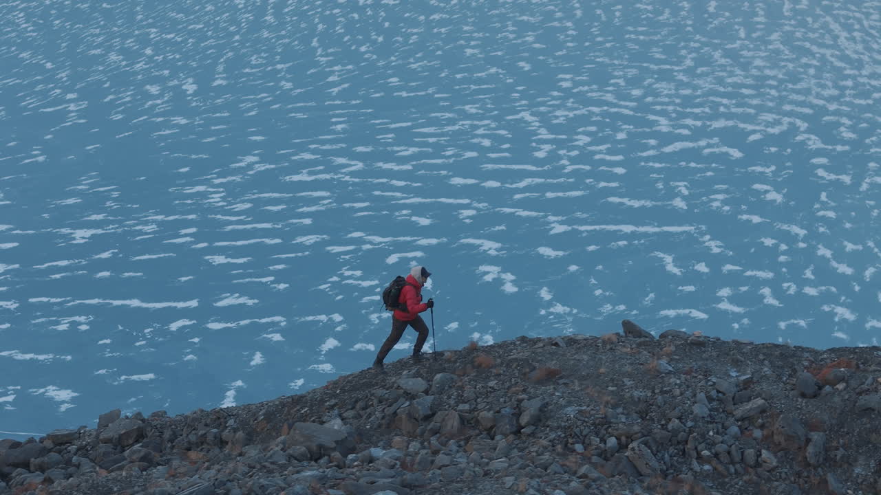lago glaciar congelado en el pico más alto del mundo el monte everest región de nepal, hombres escalando la colina con apoyo de bastón, disfrutar de la vista en asombro disparo de drone revela el paisaje vista cinematográfica, 4k