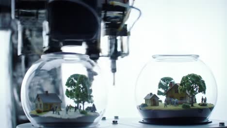 a robotic arm creates detailed miniature landscapes within glass domes, showcasing intricate models of idealized communities and nature