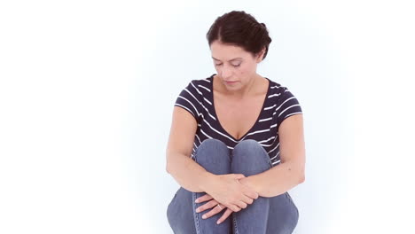 mujer infeliz sentada en el suelo