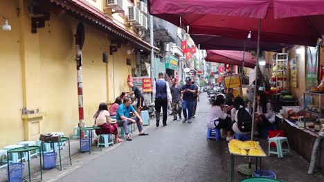 people enjoying street food in hanoi, vietnam