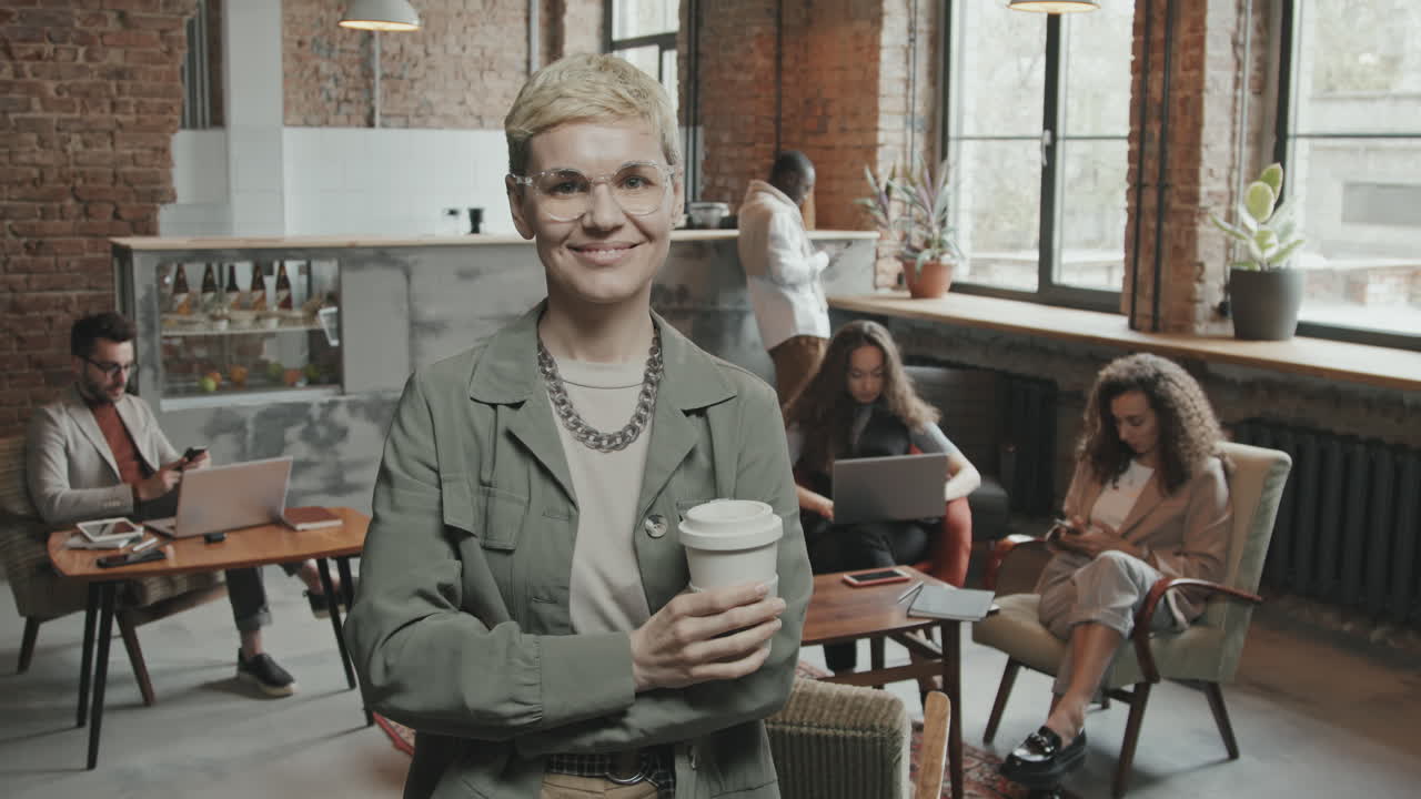 Young Smiling Woman Posing for Camera with Cup of Coffee in Hands