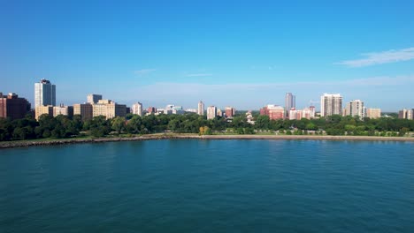 waterfront park with lush green trees blue water and apartment buildings