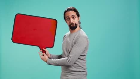 smiling man holding red speech bubble sign of empty copy space for message