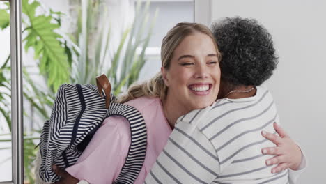 smiling caucasian nurse hugging with senior african american woman patient, slow motion