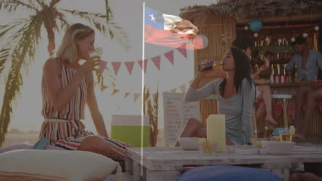 at beachside bar, two women drinking with chilean flag animation overlay