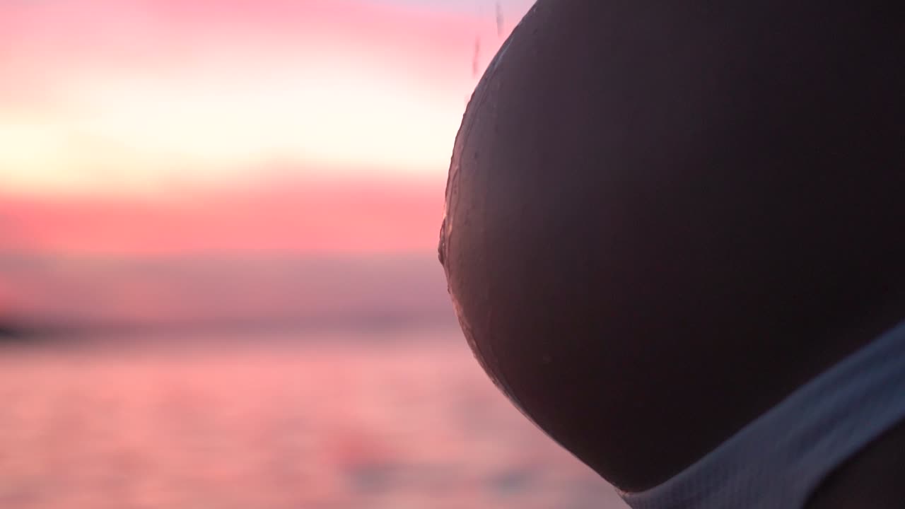 임신한 배 아기, 기대하는 어머니 배 해변에서 일몰 동안 휴식을 취하고