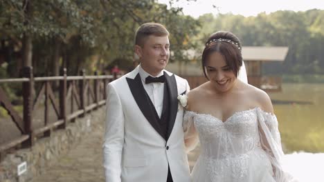 Encantadores-Recién-Casados-Novia-Caucásica-Novio-Caminando-En-El-Parque,-Tomados-De-La-Mano,-Pareja-De-Novios-Familia